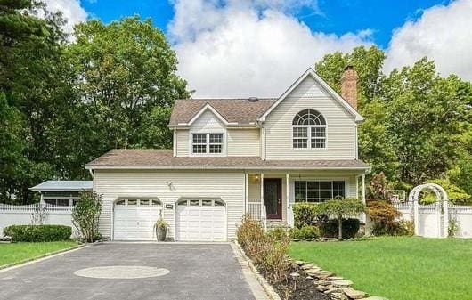 85 Mowbray St, Patchogue, NY 11772 - traditional home with asphalt driveway, a chimney, and a garage