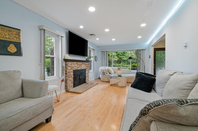 85 Mowbray St, Patchogue, NY 11772 - living room with recessed lighting, healthy amount of natural light, a fireplace, and light wood-type flooring