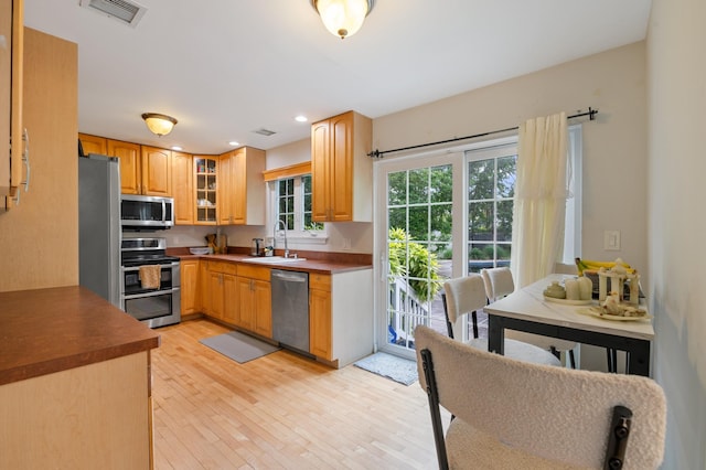 85 Mowbray St, Patchogue, NY 11772 - kitchen with stainless steel appliances, light wood-type flooring, glass insert cabinets, recessed lighting, and dark countertops