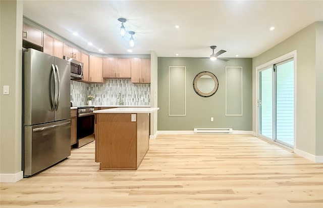 kitchen featuring appliances with stainless steel finishes, a baseboard heating unit, light wood-style flooring, tasteful backsplash, and light countertops