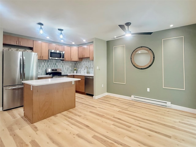 kitchen featuring appliances with stainless steel finishes, baseboard heating, light wood finished floors, a sink, and recessed lighting