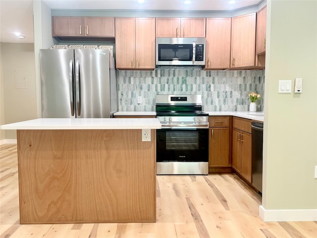 kitchen featuring stainless steel appliances, light wood-style flooring, light countertops, and a kitchen island