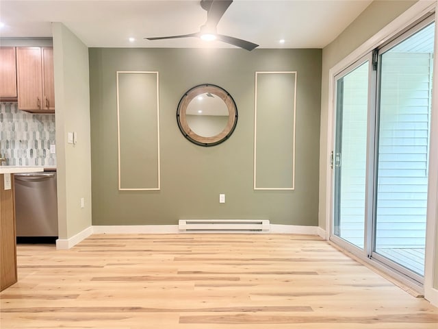empty room featuring a baseboard heating unit, a ceiling fan, light wood-style flooring, baseboards, and recessed lighting