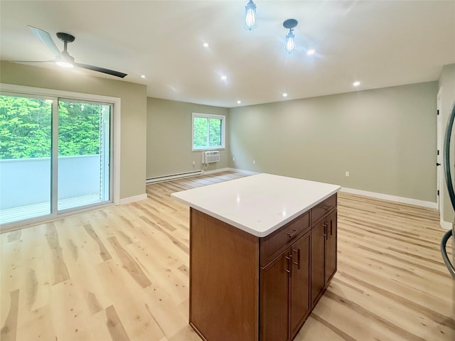 kitchen with a baseboard radiator, baseboards, light wood-type flooring, a kitchen island, and open floor plan