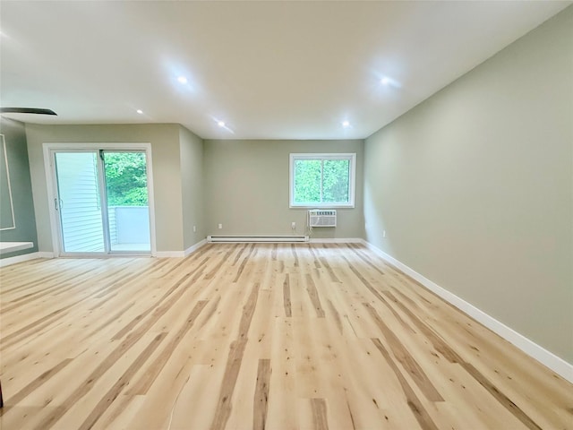 unfurnished living room with a wall mounted AC, baseboards, plenty of natural light, light wood-type flooring, and recessed lighting