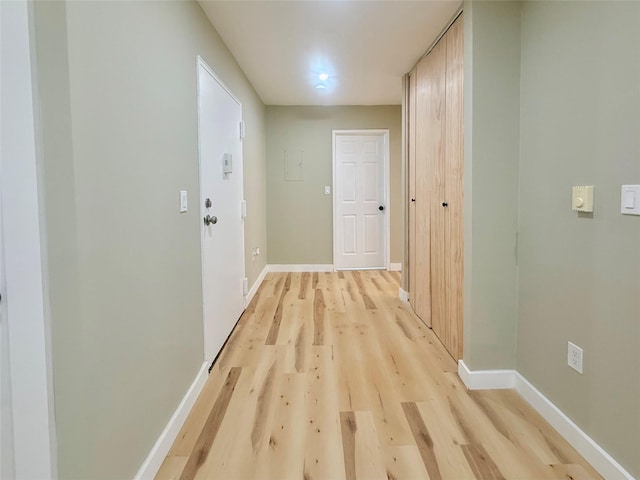 hallway with light wood finished floors and baseboards