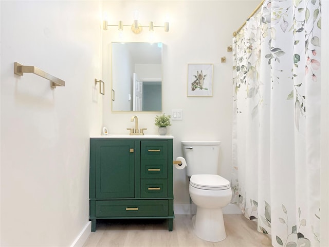 bathroom featuring toilet, vanity, and a shower with curtain