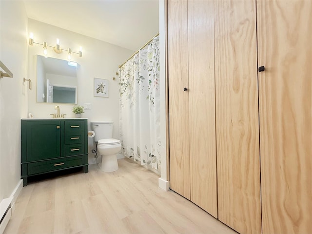 full bath with toilet, wood finished floors, and vanity
