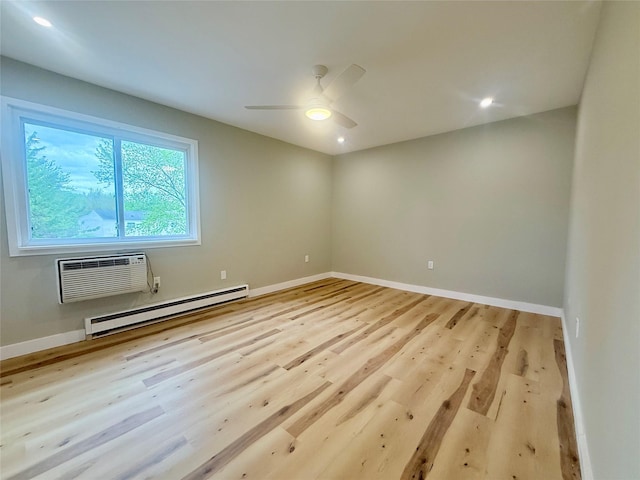 empty room featuring a baseboard heating unit, wood finished floors, a ceiling fan, baseboards, and a wall mounted AC