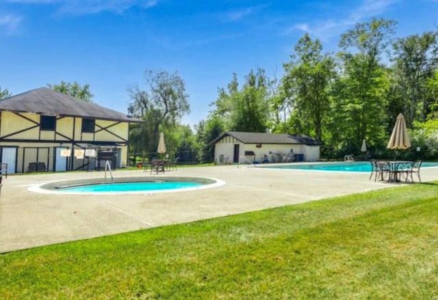 community pool featuring a lawn and a patio