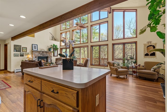 216 Cortese Rd, Call Listing Agent, PA 18405 - kitchen featuring a fireplace, open floor plan, light countertops, beamed ceiling, and light wood-style floors