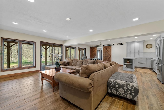 216 Cortese Rd, Call Listing Agent, PA 18405 - living room featuring a barn door, light wood-type flooring, recessed lighting, and baseboards