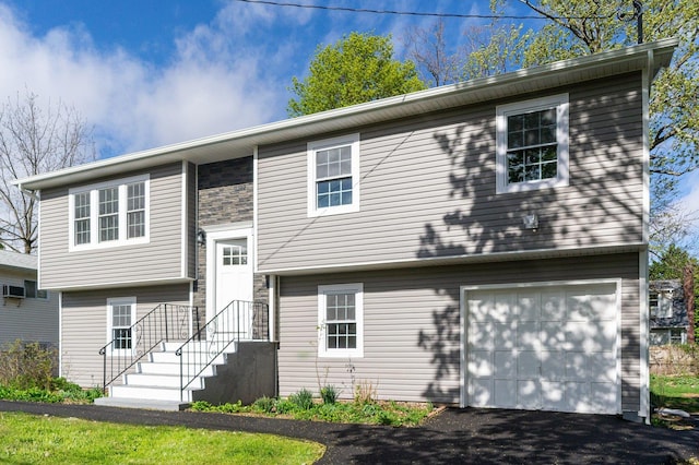 bi-level home featuring an attached garage and driveway