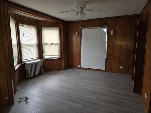 163 Villa Ave, Yonkers, NY 10704 - empty room with radiator, plenty of natural light, a ceiling fan, wood finished floors, and wooden walls