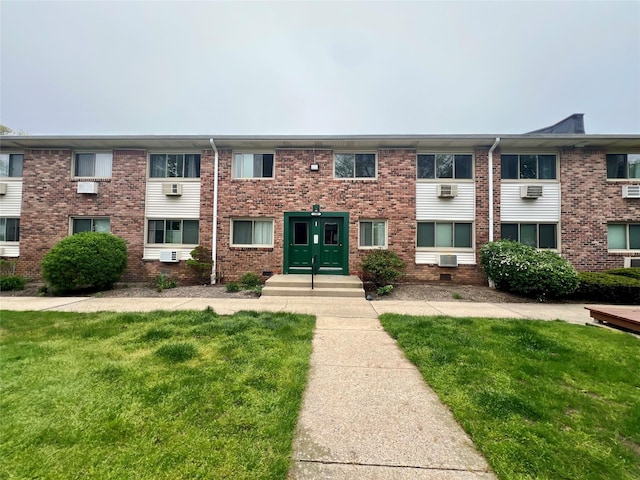 view of front facade with a front yard and brick siding