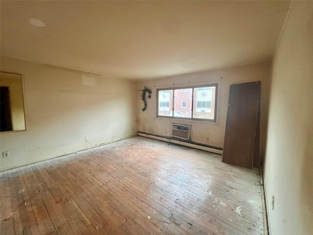 empty room with light wood-type flooring and a baseboard radiator