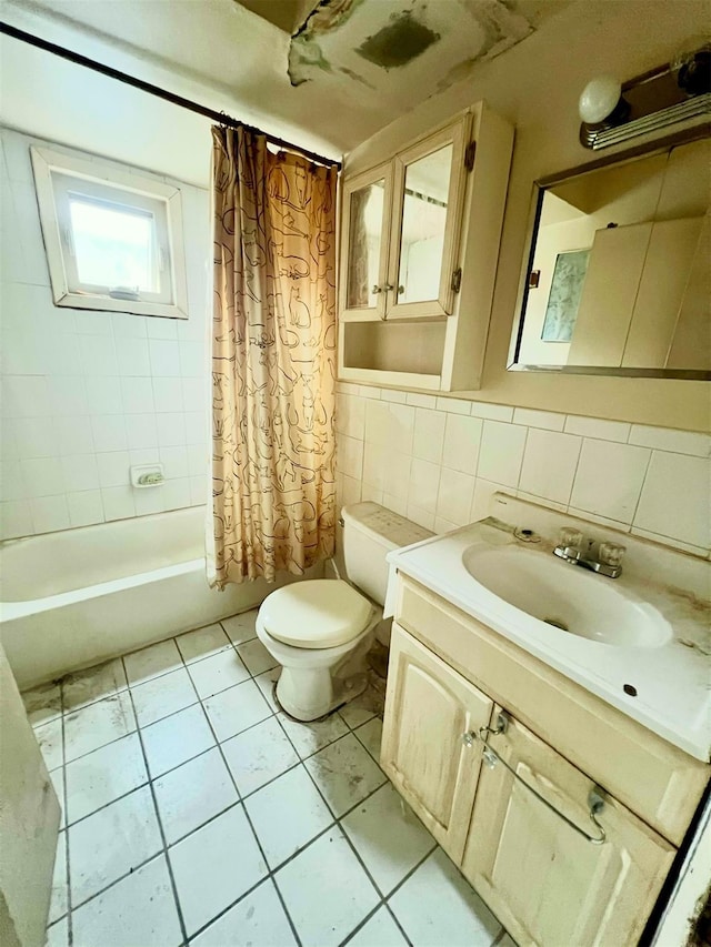 bathroom with tile walls, toilet, tile patterned floors, vanity, and shower / bathtub combination with curtain