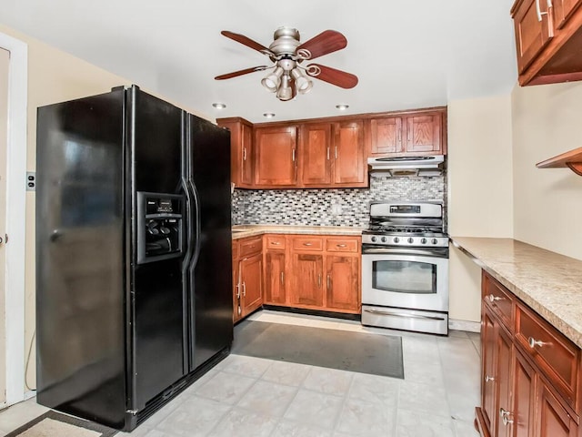 kitchen with black refrigerator with ice dispenser, stainless steel gas range, under cabinet range hood, ceiling fan, and backsplash