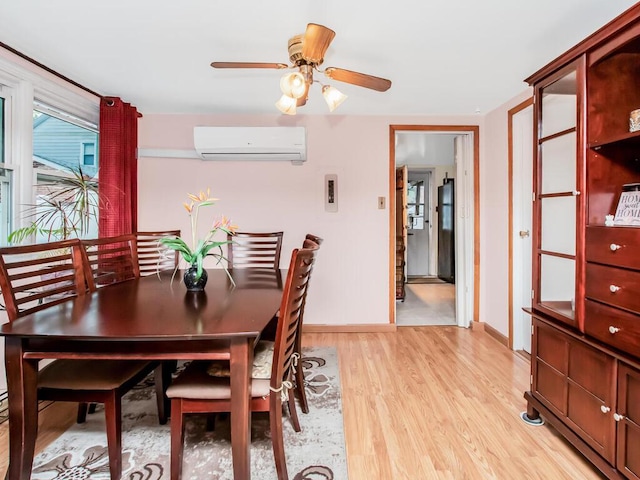 dining area featuring a wall mounted AC, light wood-style floors, baseboards, and a ceiling fan