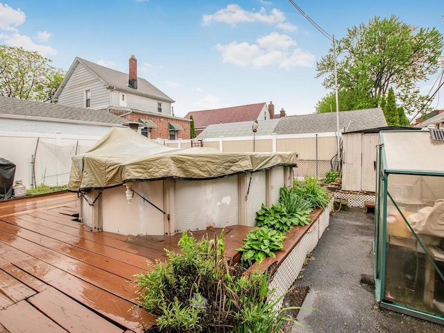 rear view of house featuring a fenced backyard and a wooden deck