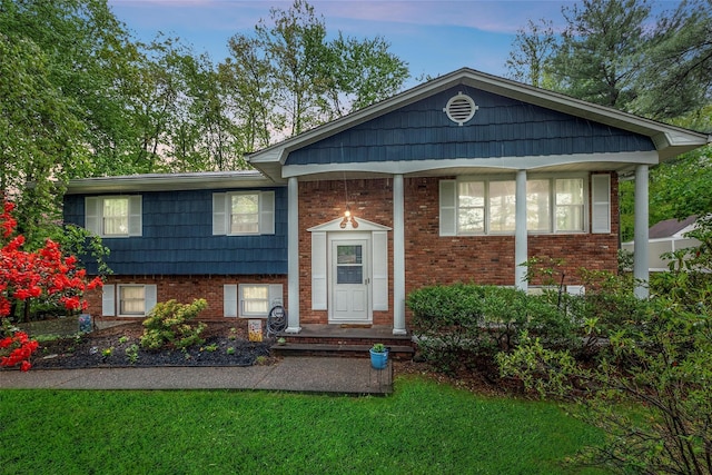 split foyer home with brick siding and a front yard