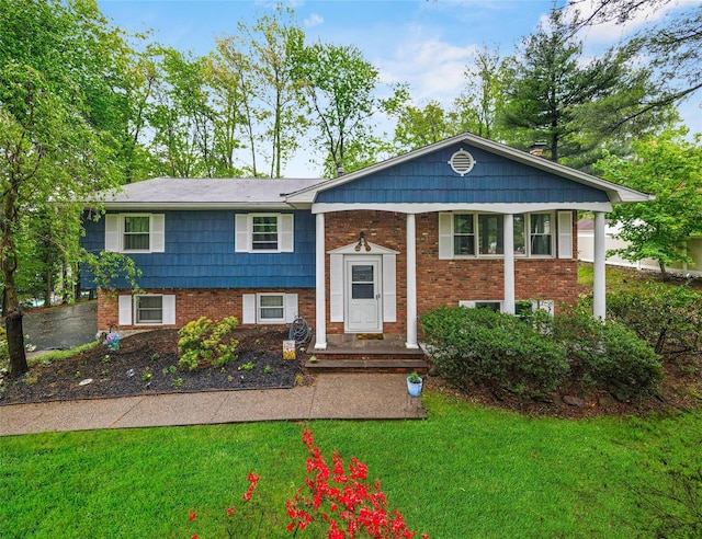 raised ranch featuring a front lawn and brick siding