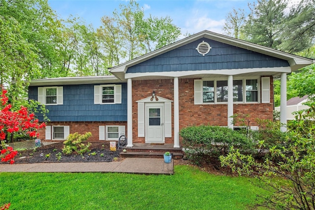 bi-level home featuring a front lawn and brick siding