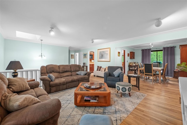 living room featuring crown molding, a skylight, and light wood finished floors