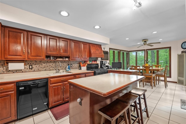 kitchen with black appliances, a sink, light tile patterned flooring, a kitchen bar, and light countertops