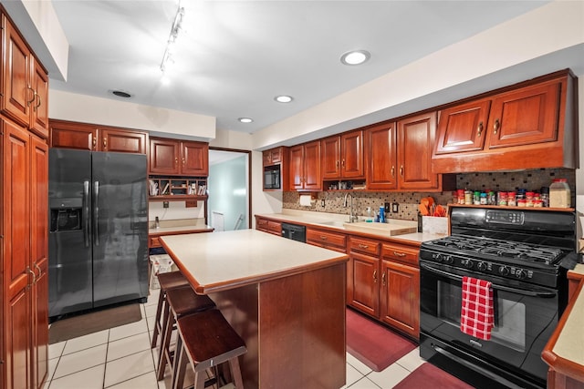 kitchen featuring black appliances, light countertops, light tile patterned flooring, decorative backsplash, and recessed lighting