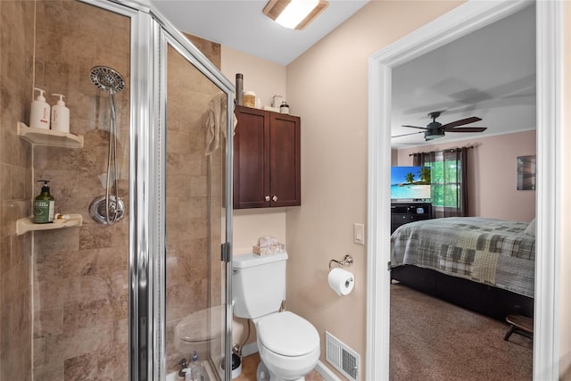 bathroom with ensuite bathroom, a shower stall, toilet, and a ceiling fan