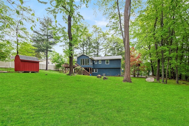 view of grassy yard featuring a storage shed, an outbuilding, and stairway