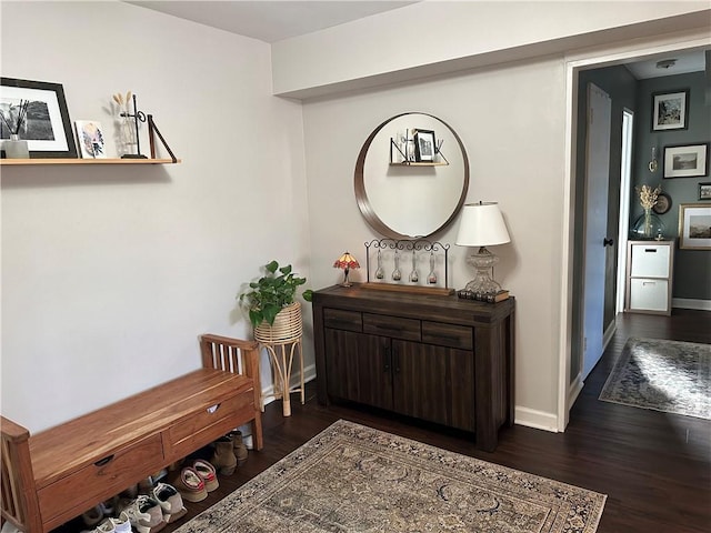 hallway featuring dark wood-type flooring and baseboards