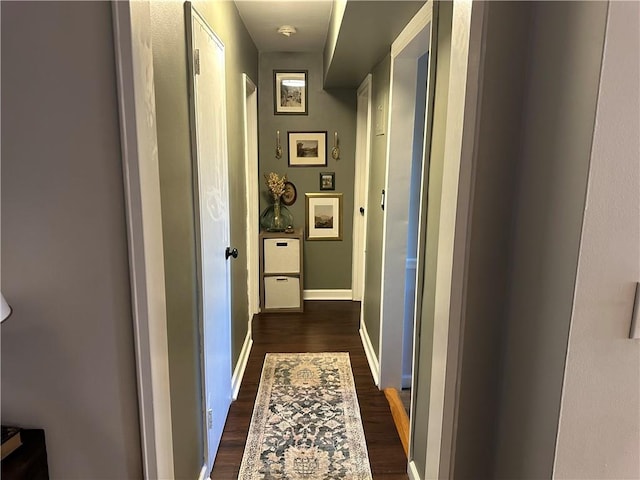 hallway with dark wood-style flooring and baseboards