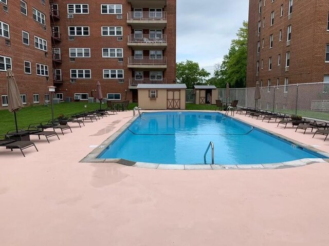 community pool with fence and a patio area