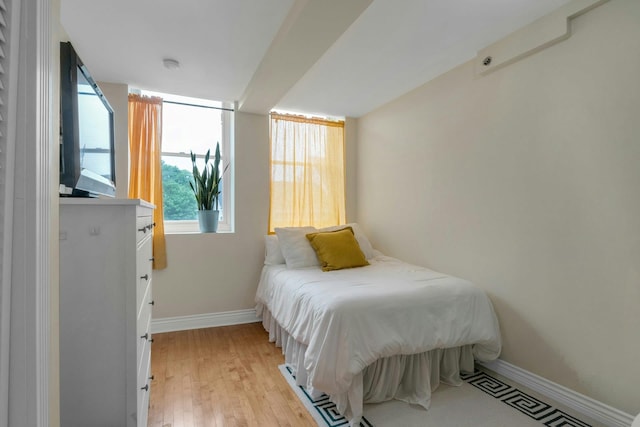 bedroom with baseboards and light wood-style flooring