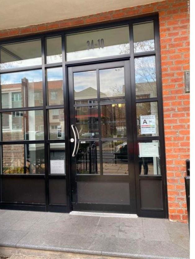 property entrance featuring brick siding and french doors