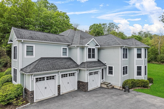 view of front of property featuring asphalt driveway, a garage, a shingled roof, and stone siding