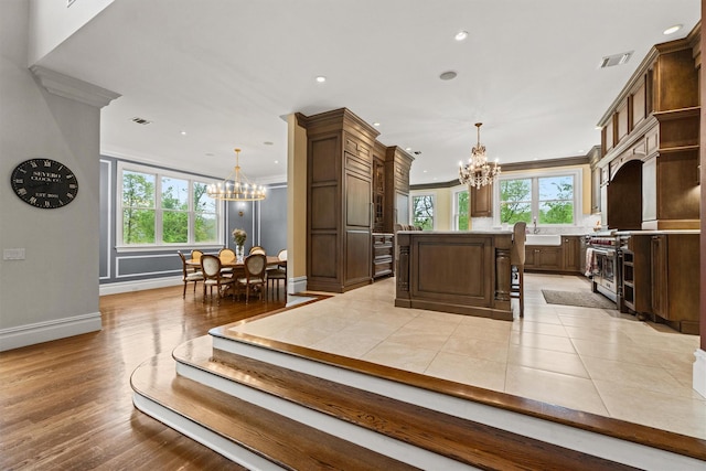 kitchen with a chandelier, healthy amount of natural light, light countertops, baseboards, and recessed lighting