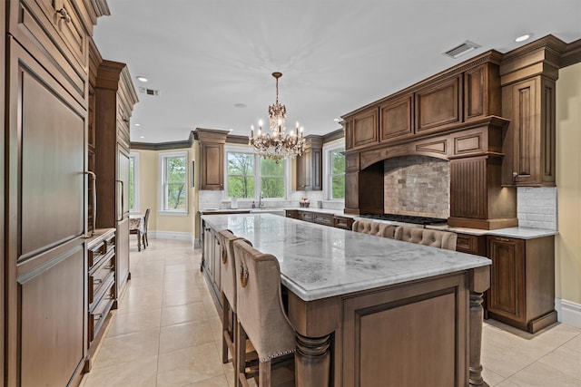 kitchen featuring a chandelier, baseboards, recessed lighting, a center island, and tasteful backsplash