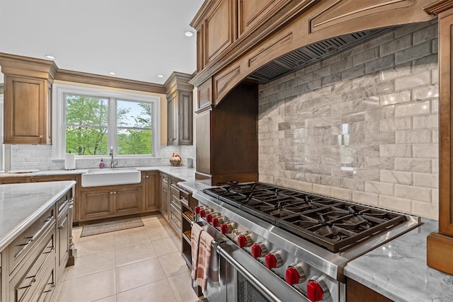 kitchen with a sink, high end stainless steel range, tasteful backsplash, and recessed lighting