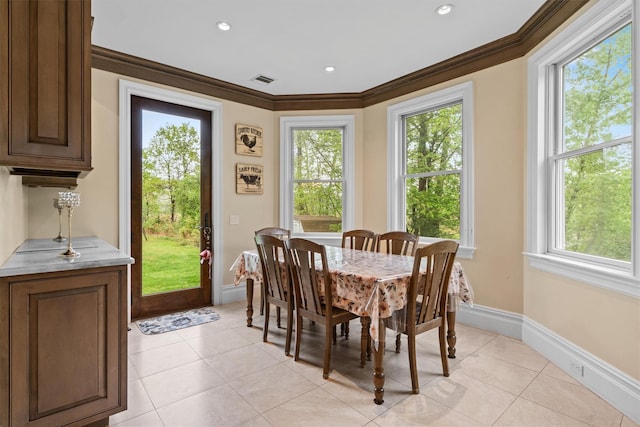dining space with plenty of natural light, baseboards, crown molding, light tile patterned floors, and recessed lighting