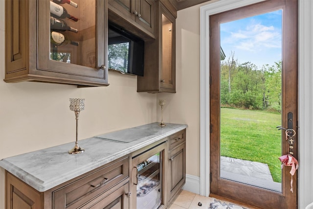 indoor dry bar featuring beverage cooler and light tile patterned floors