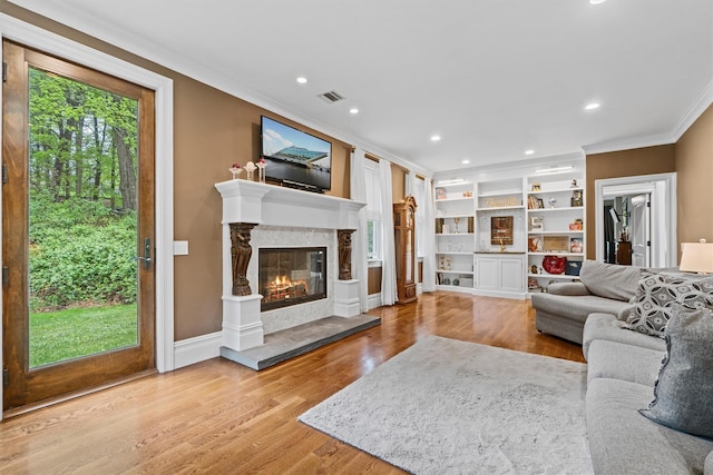 living room with crown molding, a fireplace, wood finished floors, recessed lighting, and built in shelves