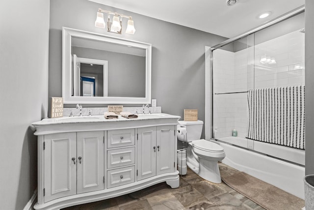 full bath featuring double vanity, shower / bath combination with glass door, and toilet