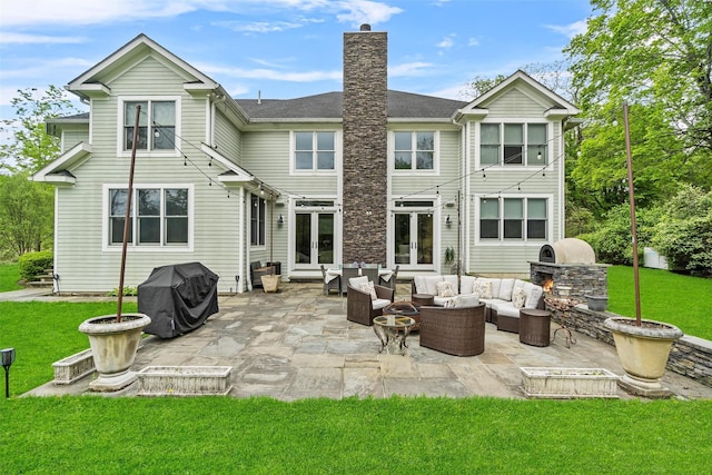 back of property with french doors, outdoor lounge area, a lawn, and a patio