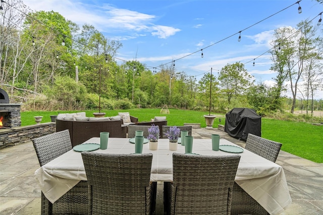 view of patio / terrace with an outdoor living space with a fireplace, a grill, and outdoor dining space