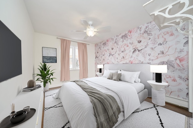6629 74th St, Middle Village, NY 11379 - bedroom with wood finished floors, wallpapered walls, ceiling fan, baseboards, and an accent wall