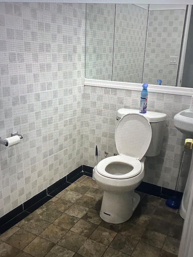 427 New Lots Ave, Brooklyn, NY 11207 - bathroom featuring toilet, tile walls, and stone finish floors