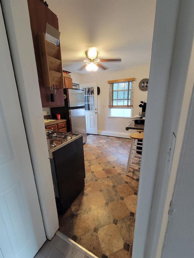 53 Bayview Ave, East Islip, NY 11730 - kitchen with freestanding refrigerator, gas range, ceiling fan, and baseboards